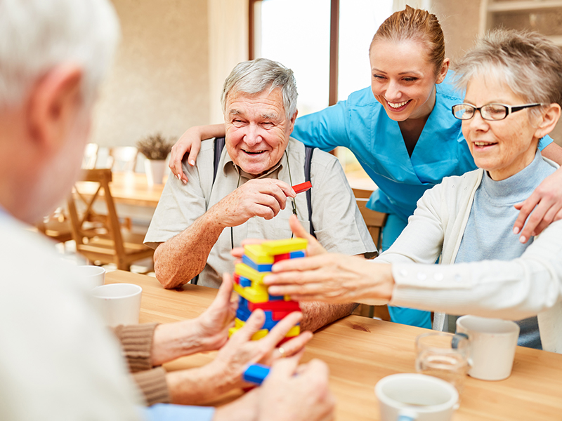 Affinity homecare care services page. Photo shows a carer working with some elderly people at a craft session.
